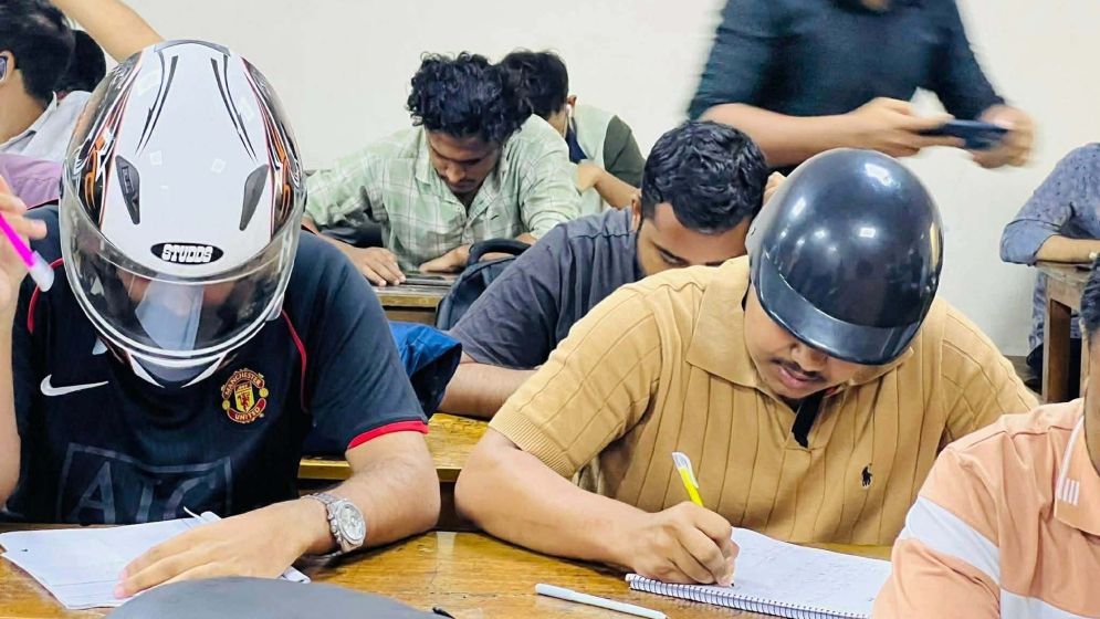 হেলমেট পরে পরীক্ষার হলে জবি শিক্ষার্থীরা, জানা গেল কারণ